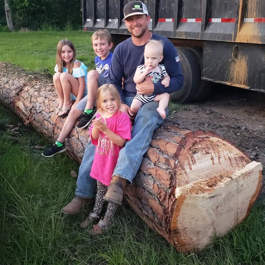 Brian Kinsey and his kids on a log at the job site